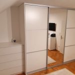 Schwebetürenschrank mit Spiegeltür neben einer Kommode