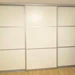 Geschlossener weißer Schwebetürenschrank