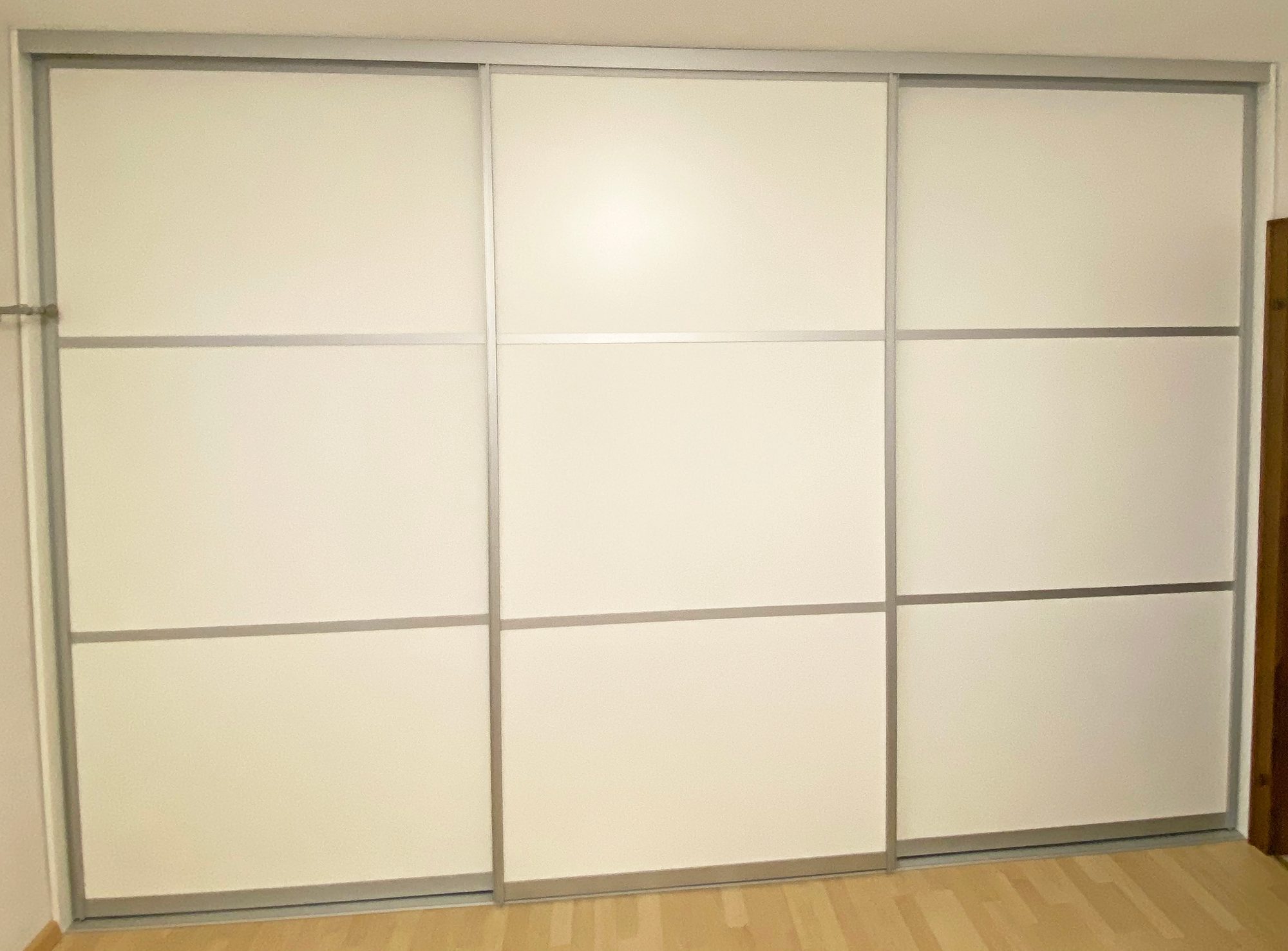 Geschlossener weißer Schwebetürenschrank