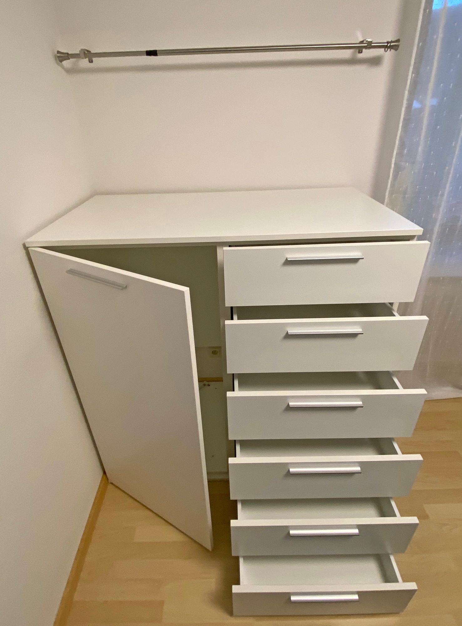 Kommode mit geöffneter Tür und Schubkästen
