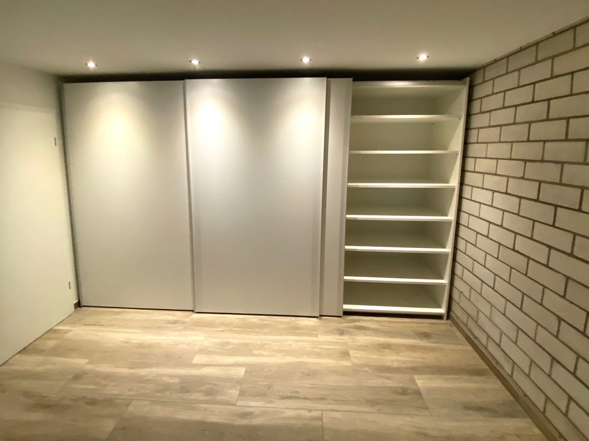 Schwebetürenschrank mit offenem Regal am Rand