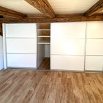 Schwebetürenschrank unter alten Holzbalken