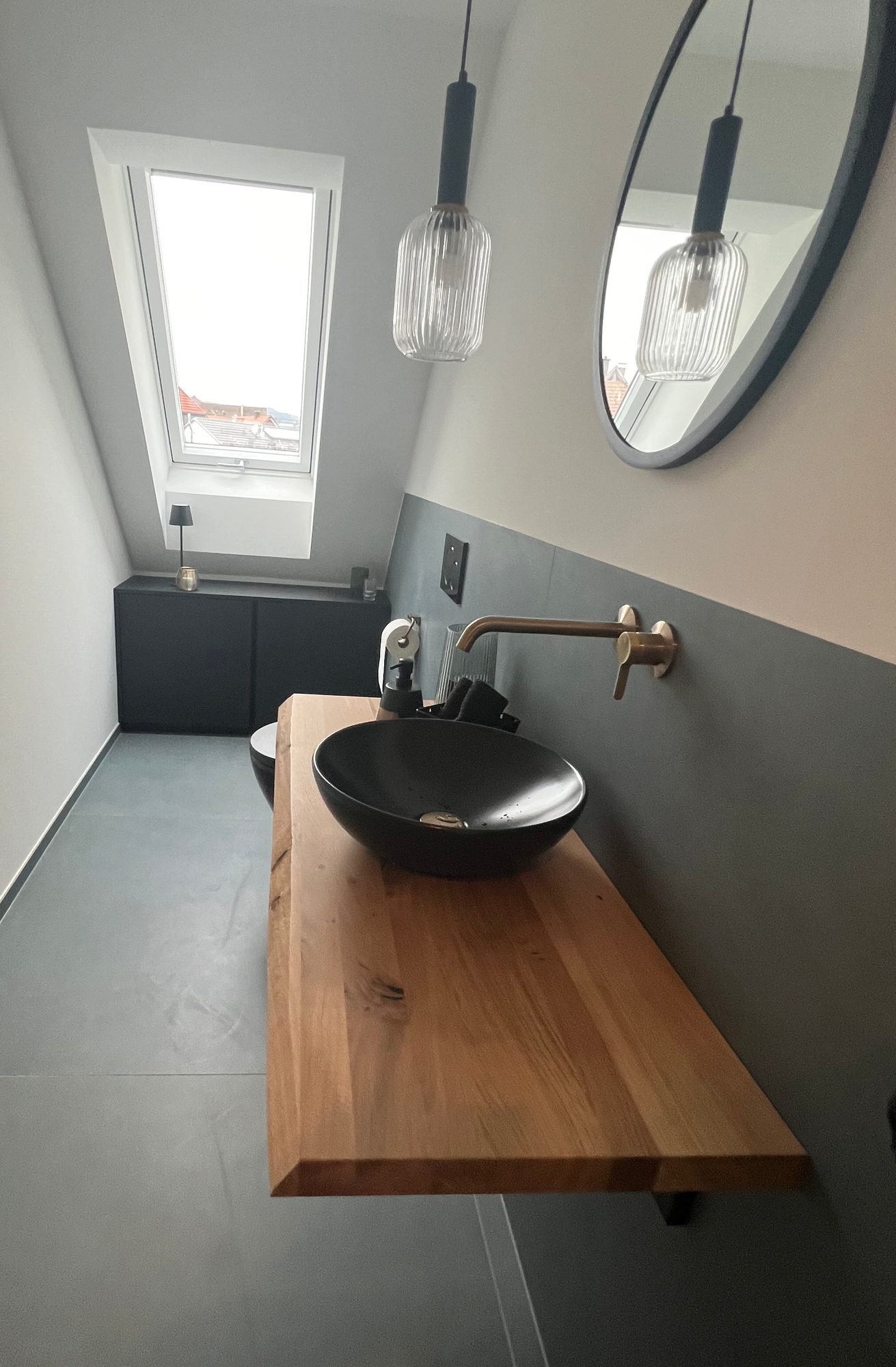 Waschplatz mit Holzkonsole vor dem Dachfenster