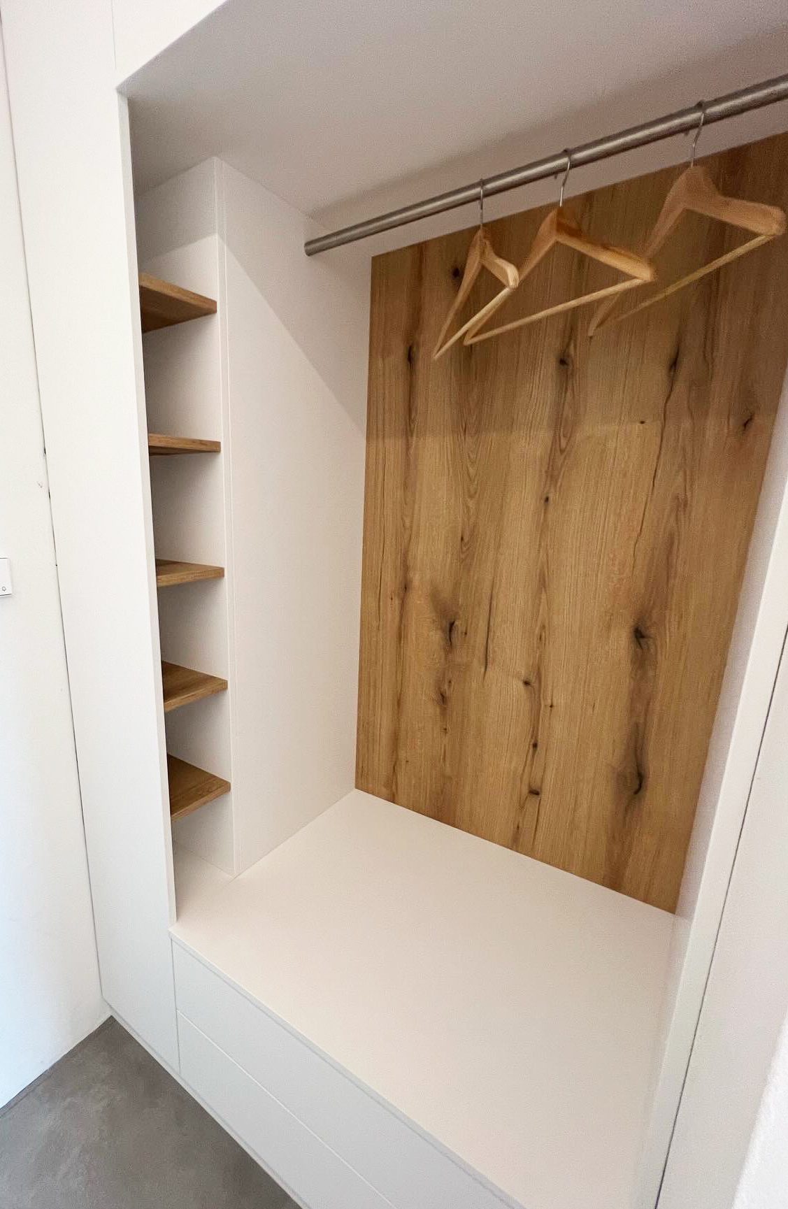Garderobennische mit Kleiderstange und Rückwand in Holzoptik