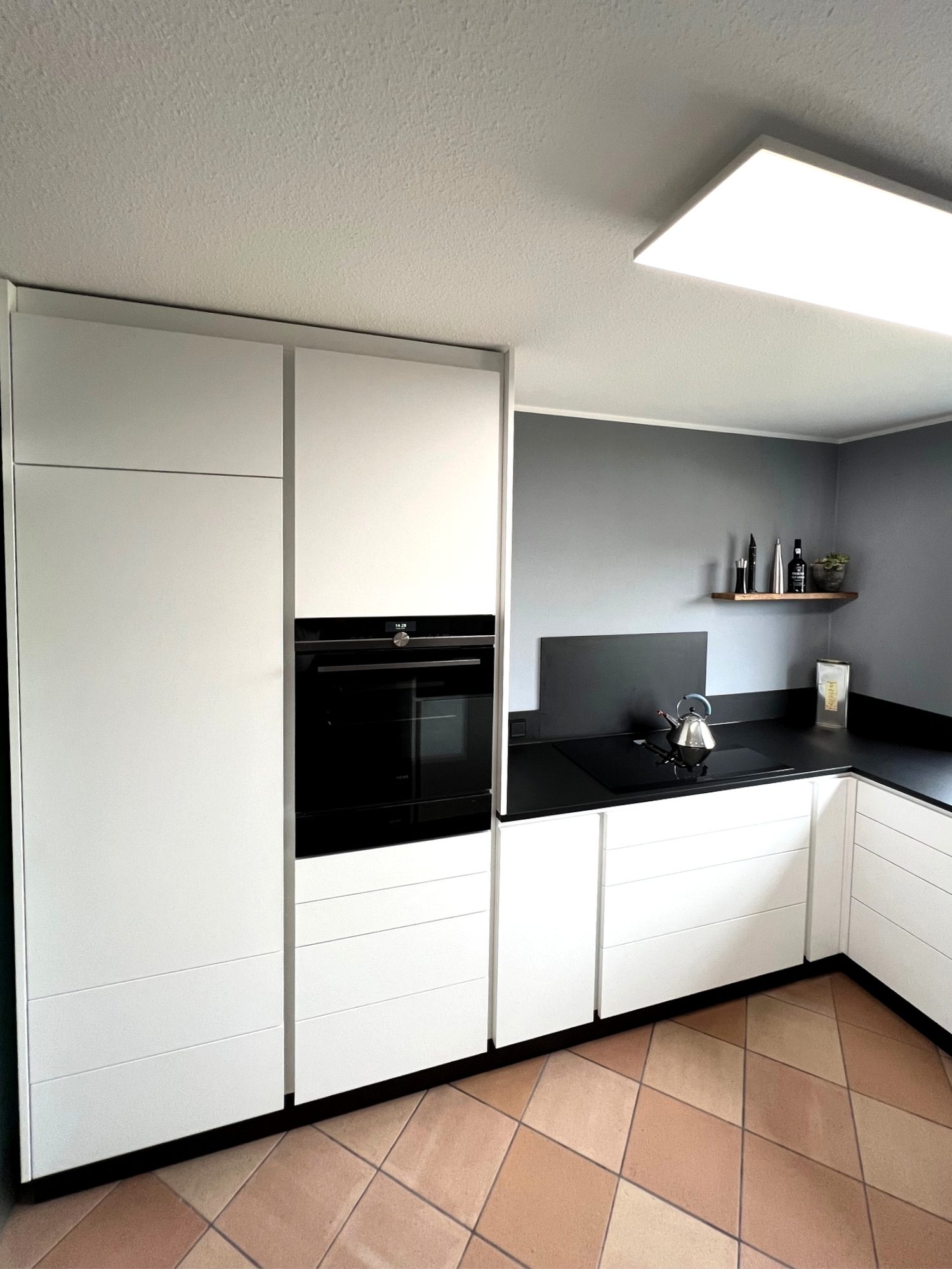 Weiße Küche mit Hochschrank und Backofen