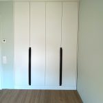 Weißer Einbauschrank mit langen schwarzen Griffen