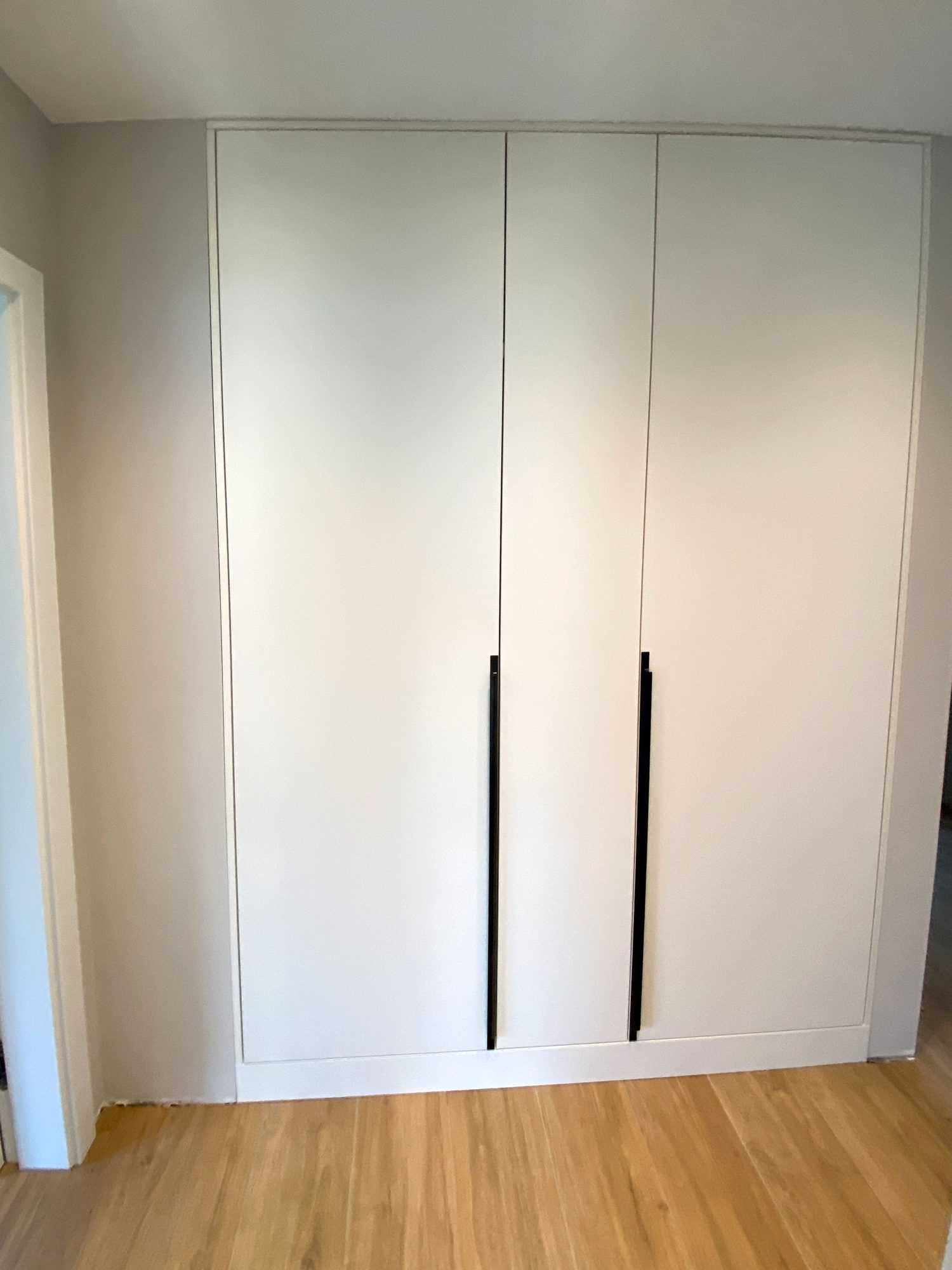 Weißer Einbauschrank mit zwei langen Griffen