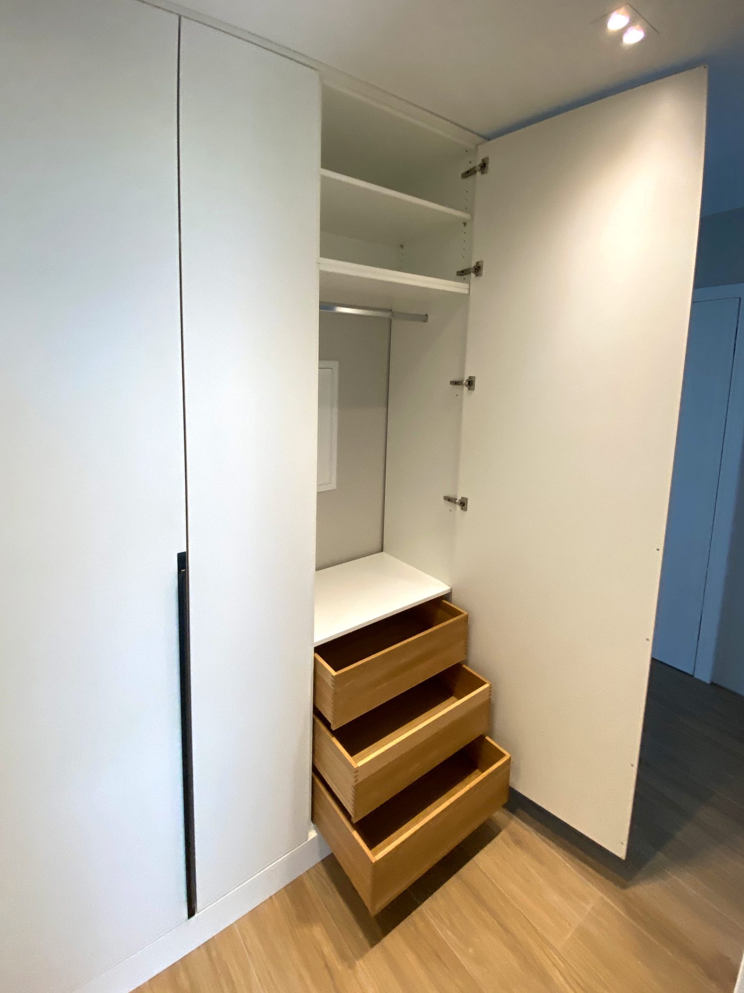 Geöffneter Schrank mit Schubkästen in Holzoptik