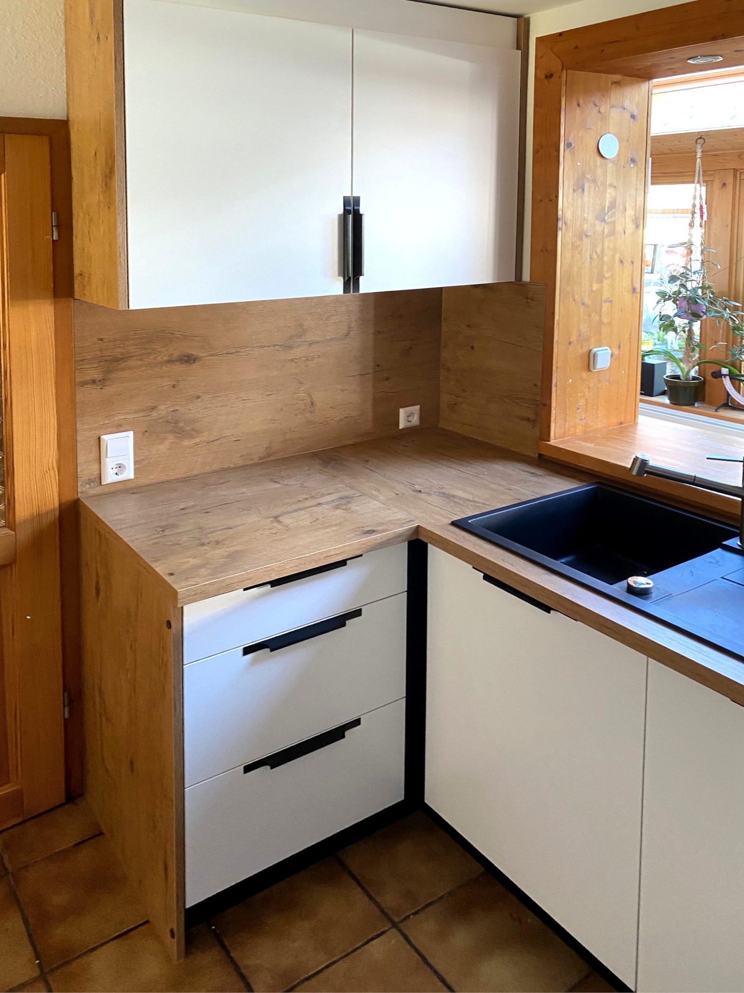 Küchenecke mit Hängeschrank und Rückwand in Holzoptik