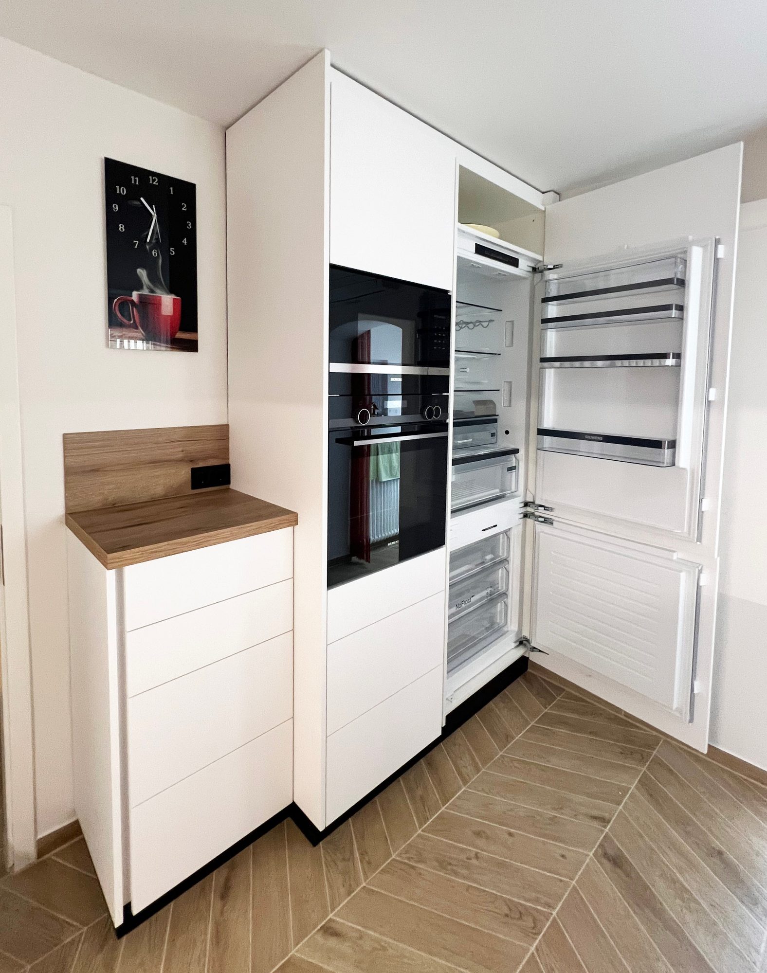 Hochschrankwand mit geöffnetem Einbaukühlschrank
