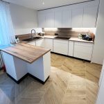 Weiße U-Küche mit Theke und Arbeitsplatte in Holzoptik